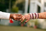 Close-up of intricately detailed henna designs on hands, highlighting a traditional Indian wedding moment.